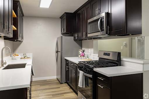 A kitchen with black cabinets and a white countertop.