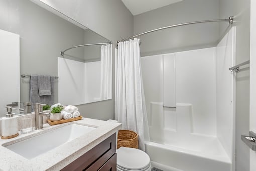 A white bathroom with a towel on the counter.