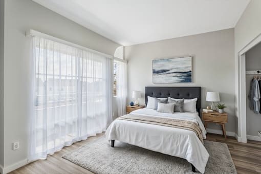 A bedroom with a large bed and a painting on the wall.