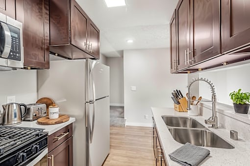 A kitchen with brown cabinets and a stove top oven.