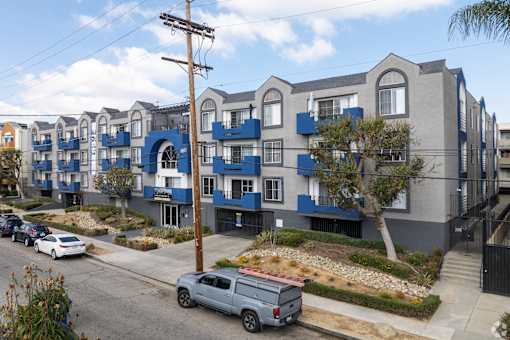 A row of modern townhouses with blue trim and balconies.