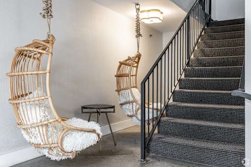 Two hanging chairs with a table in between them.