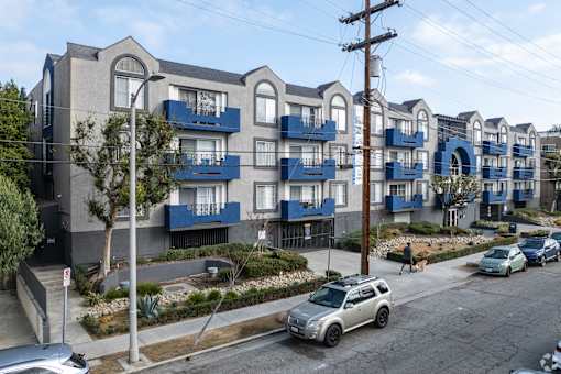 A row of modern apartment buildings with blue balconies.