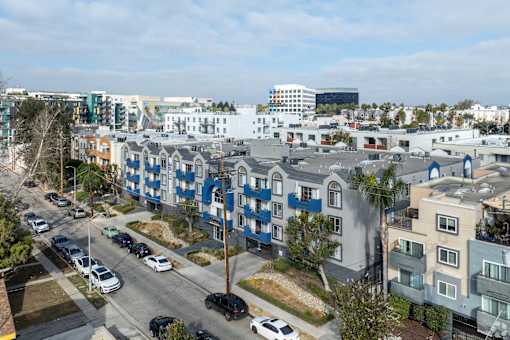 A street view of a residential area with cars parked on the side of the road.