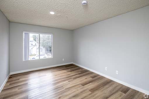 A room with wooden flooring and a window.