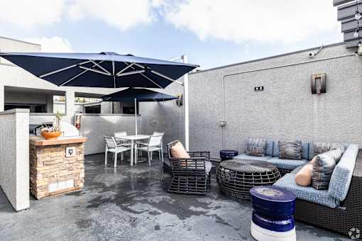 A patio with a table, chairs, and a sofa.