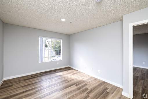 A room with a window and wooden flooring.