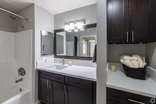 A bathroom with a white sink and a mirror above it.