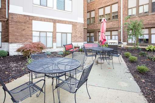 A patio with a table and chairs is surrounded by a brick building.