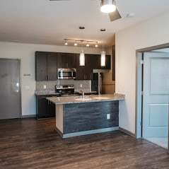 A kitchen with a white counter top and a stainless steel refrigerator.