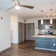A kitchen with a large island and a ceiling fan.