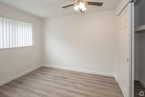 A room with a ceiling fan and a door.