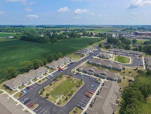 A bird's eye view of a residential area with houses and parked cars.