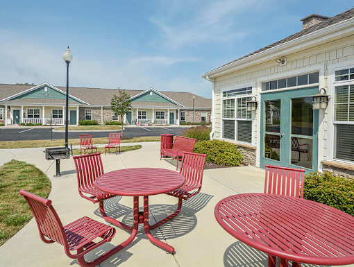 A red table and chairs are set up outside a building.