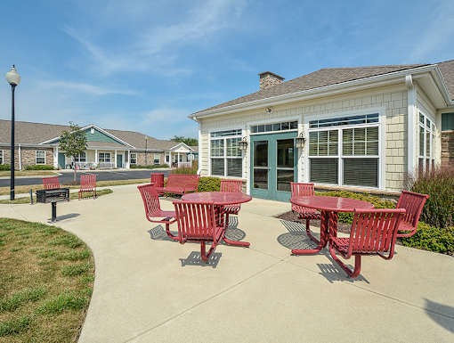 A red table and chairs are set up outside a building.