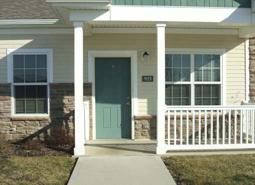 A house with a green door and a white porch.