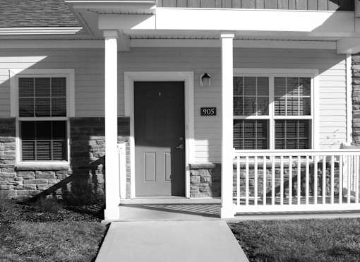 A black and white image of a house with the number 905 on the front door.