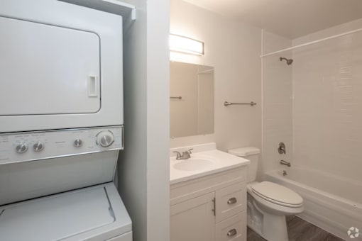 A white oven and sink in a small bathroom.