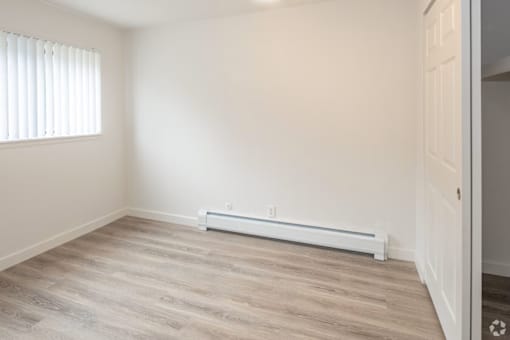 A room with a window and a radiator on the wall.