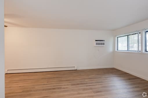 Empty room with wooden floor and white walls.