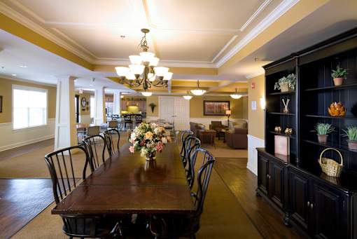 A dining room with a long table set for a meal.