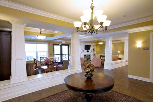 A large room with a table and chairs in the middle.