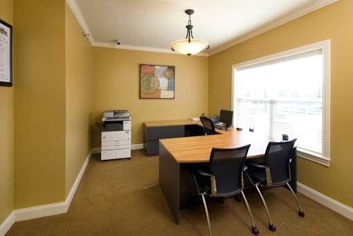 A room with a desk and chairs.