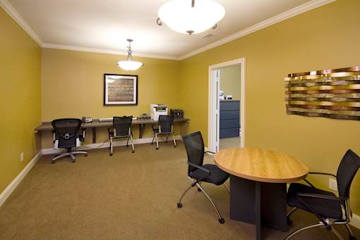 A conference room with a table, chairs, and a framed picture on the wall.