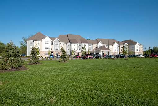 A large white building with a green lawn in front.