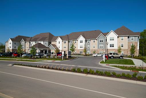 A row of houses with cars parked in front.