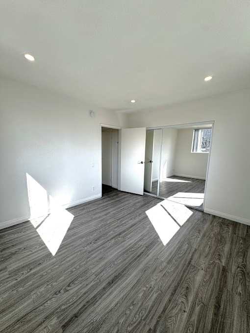 A room with wooden flooring and white walls.