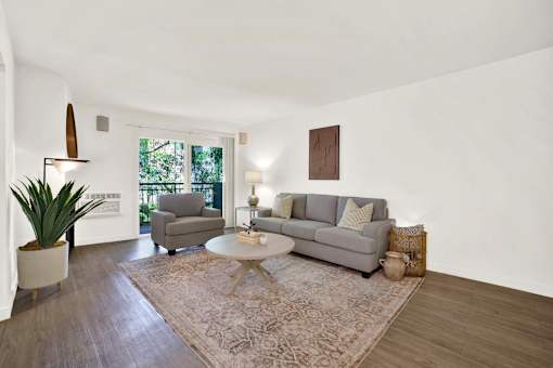 A living room with a grey couch and a rug at Westwood Riviera Apartments, Los Angeles, 90024