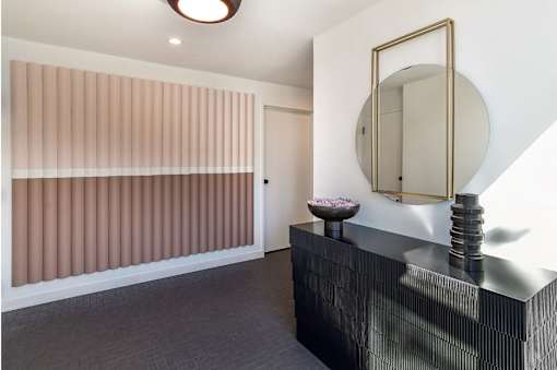 a hallway with a black dresser and a mirror and a door at 8535 Colgate-Fully Furnished Apartments, Los Angeles, CA