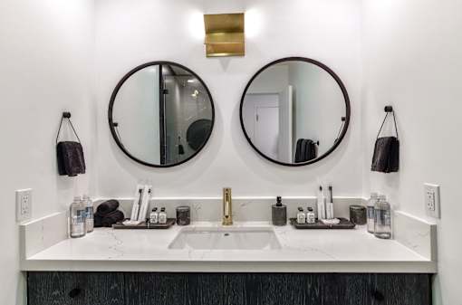 two mirrors above a bathroom sink in a hotel room at 8535 Colgate-Fully Furnished Apartments, Los Angeles