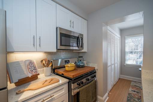 A kitchen with a stove, microwave, and refrigerator.