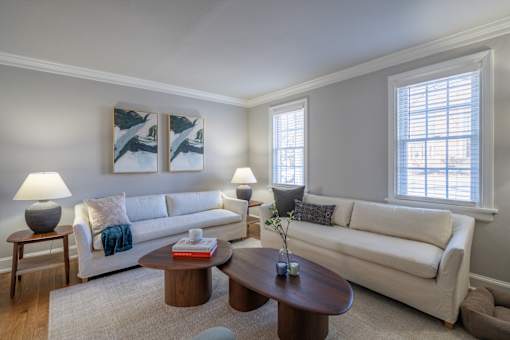 A living room with a white couch, a coffee table, and two lamps.