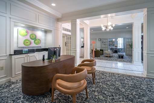 A reception area with a wooden desk and chairs.