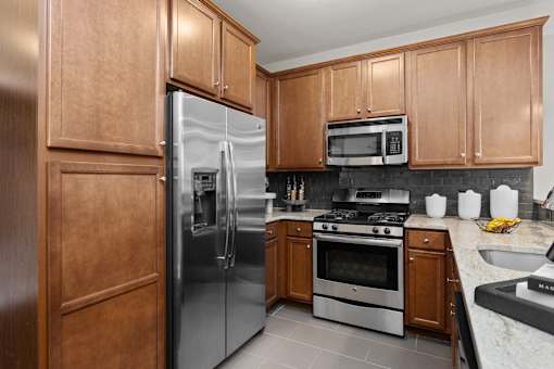 A kitchen with a refrigerator, oven, microwave, and sink. at Merion at Cross Keys Apartments, Williamstown