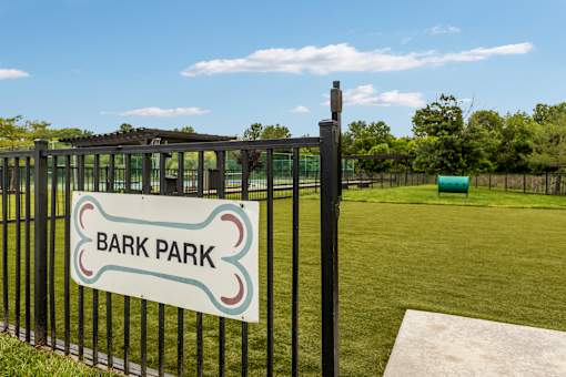 A sign that says Bark Park is on a black fence.