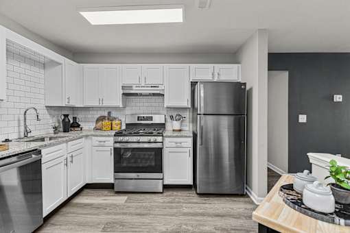 A modern kitchen with stainless steel appliances and white cabinets.
