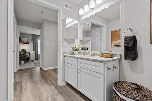 A bathroom with a marble countertop and a large mirror.