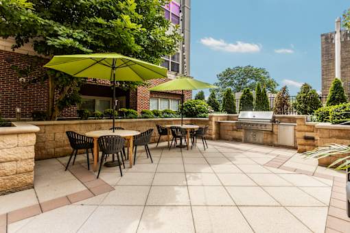 A patio with a table and chairs under a green umbrella.