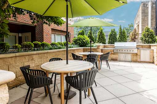 A patio with a table and chairs under a green umbrella.