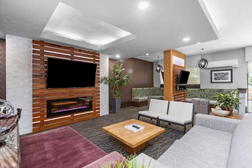 A modern living room with a fireplace and a flat screen TV.