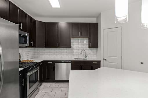 A kitchen with black cabinets and a white countertop.