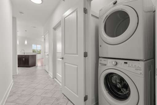A laundry room with a washer and dryer stacked on top of each other.