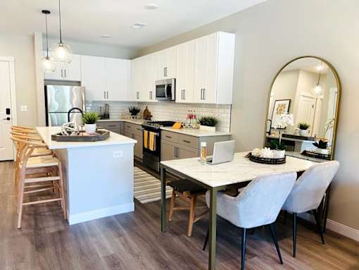 A modern kitchen with a dining table and chairs.
