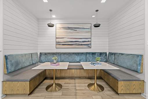 A modern dining area with a wooden table and blue cushioned booths.
