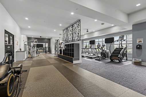 A gym with a variety of equipment including treadmills, stationary bikes, and weight machines.