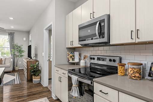 A modern kitchen with a stove, oven, and microwave.